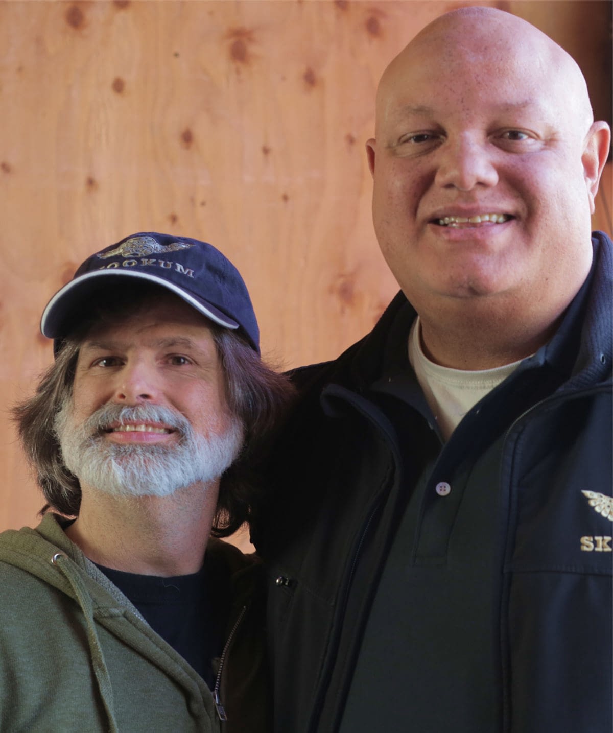Two employees stand next to each other as if posing for an award photo.
