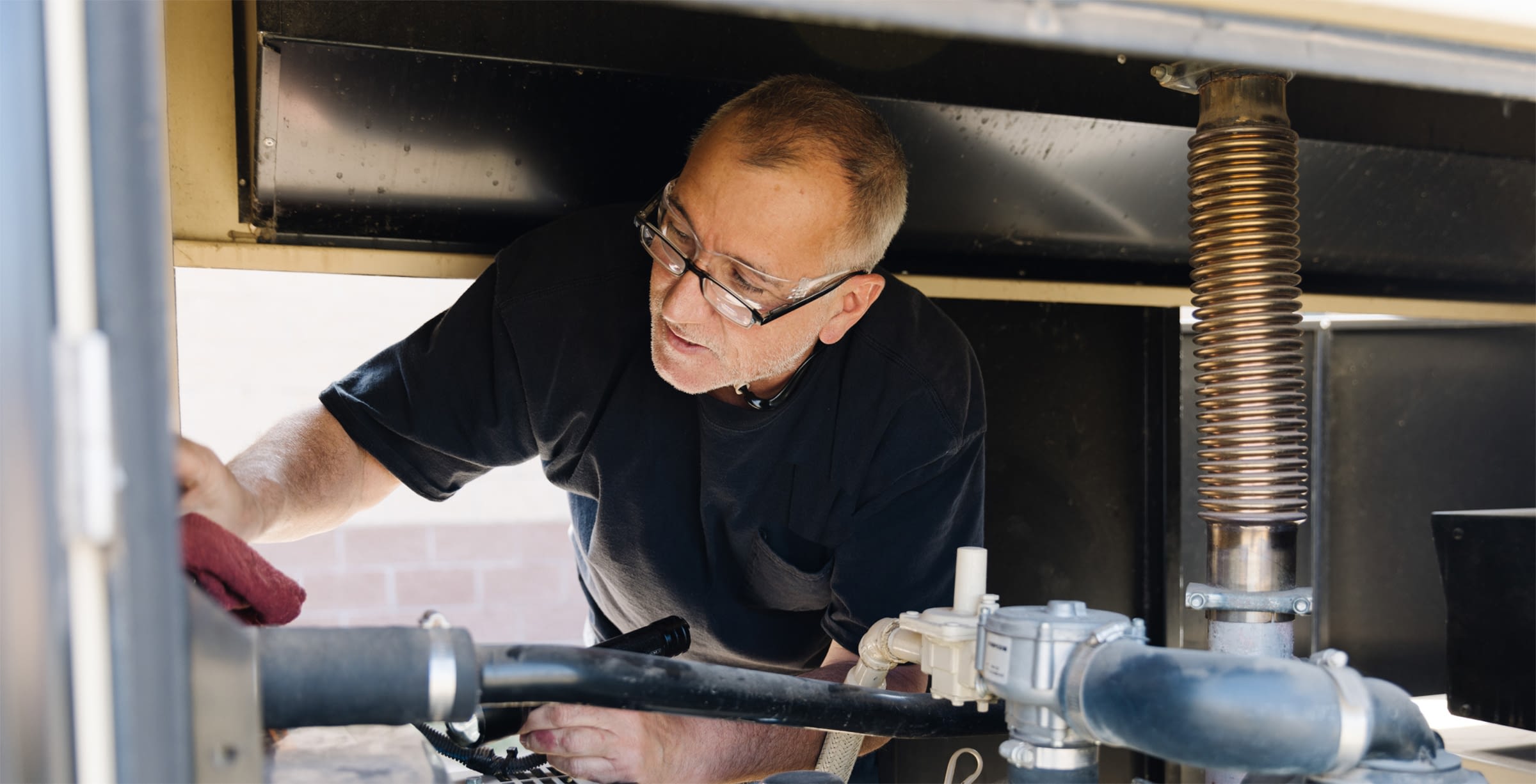 An employee servicing large industrial equipment.