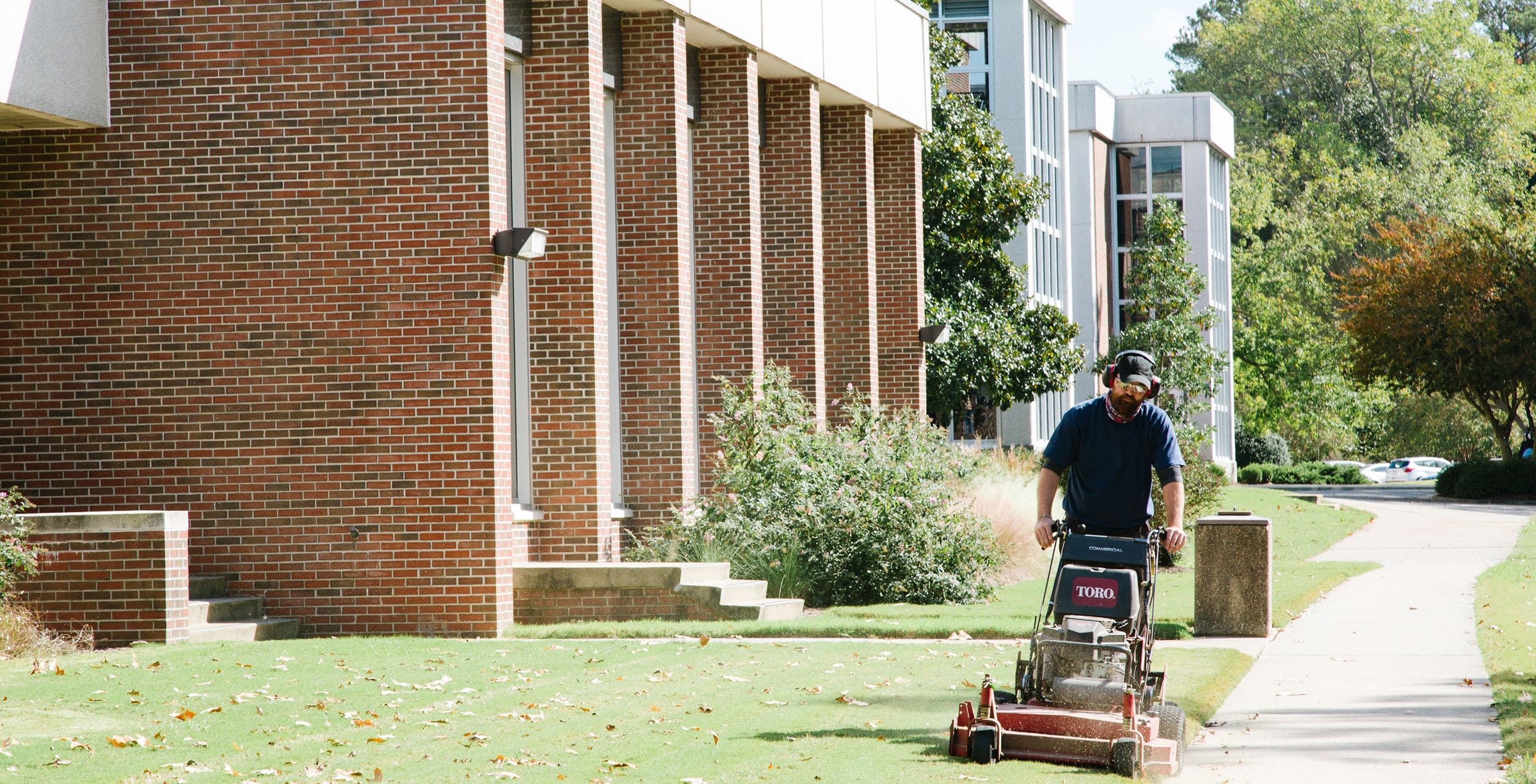 A worker mowing the grass for client