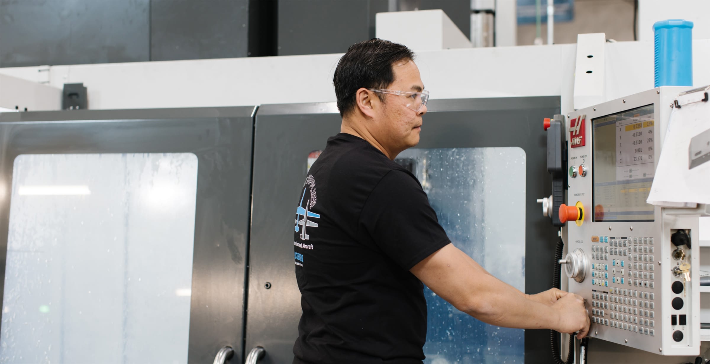 Employee in safety glasses working with cutting edge machinery.