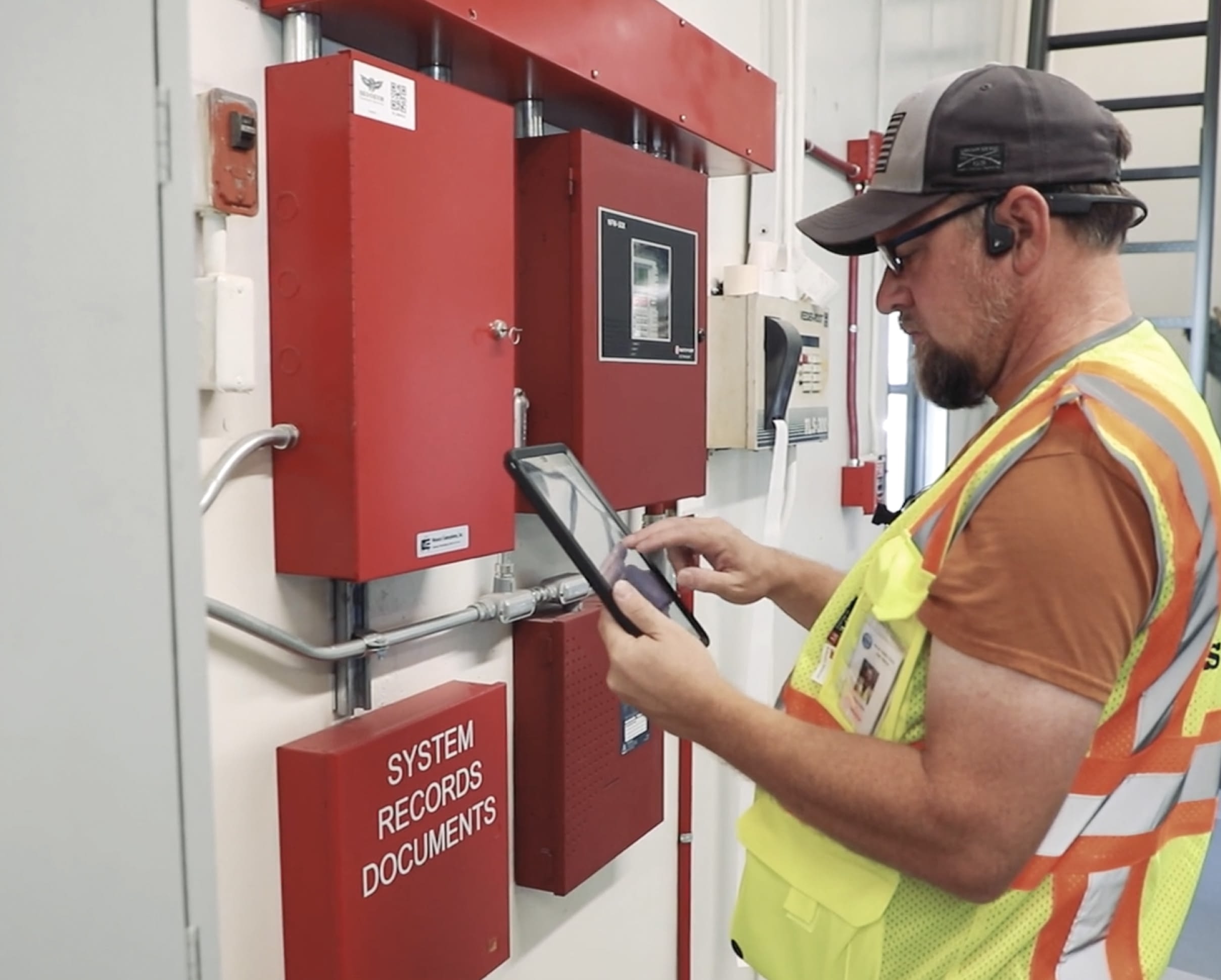 An employee in a safety vest running an analytics tool.